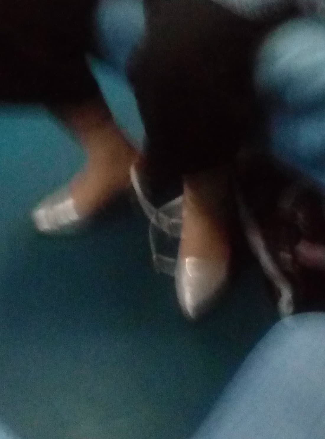 Interior train shot showing a passenger's legs with sheer stockings, feet tucked neatly under the seat during transit.