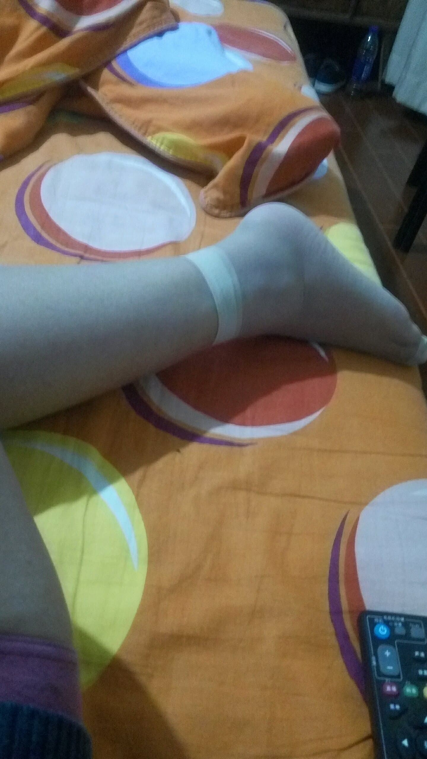 Single foot partially encased in short stockings, ankle exposed with toes curled to emphasize arch and texture.