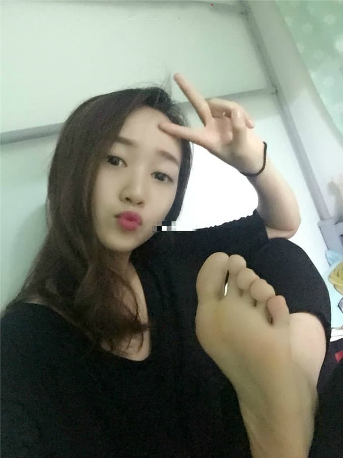 Playful portrait of feet in mismatched stockings, toes peeking out as sunlight highlights the nylon sheen and texture.