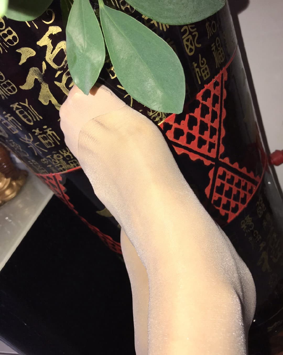 Bare feet resting casually with nylons pushed down to the ankles and socks discarded nearby