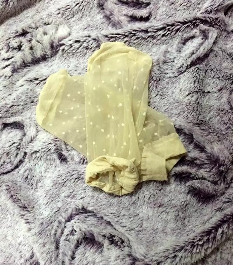 Ankle-length polka dot stockings rolled slightly to reveal the soft arch and exposed toes of a bare foot