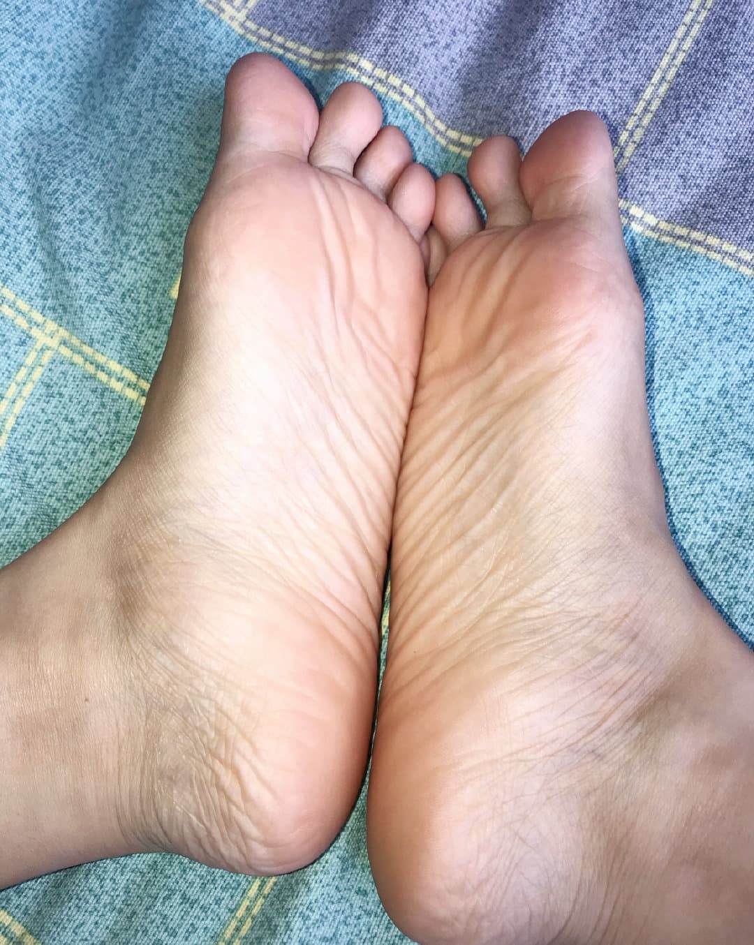 Small, delicate foot in a slightly stretched cotton sock, showing compact toes and gentle arch detail