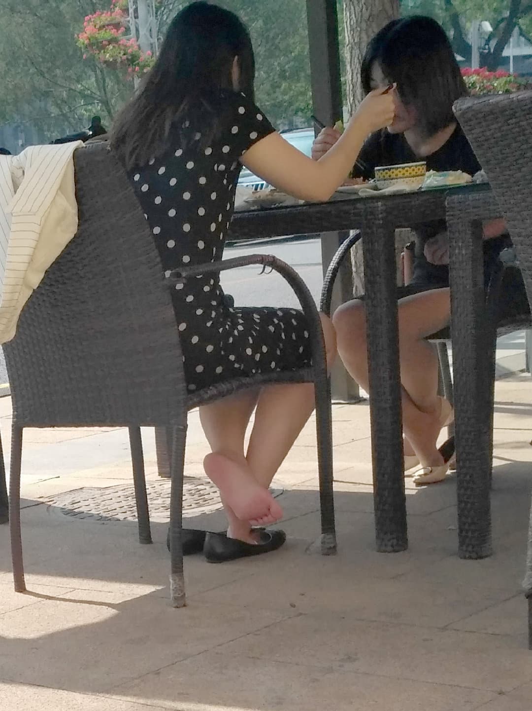 Balcony view with bare feet casually resting on the railing, distant skyline blurred beyond