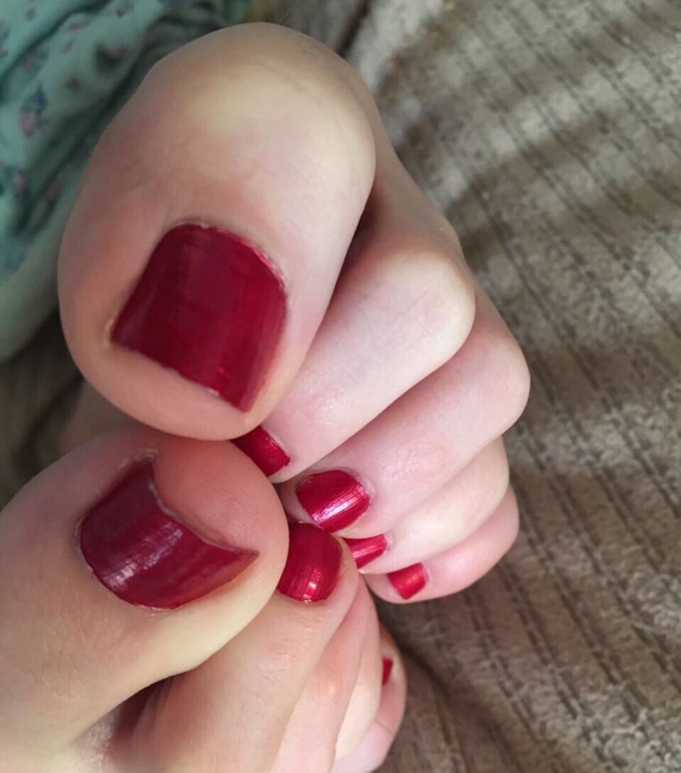 Well-worn cotton socks snug around feet, outlines of toes and arches visible through soft fabric