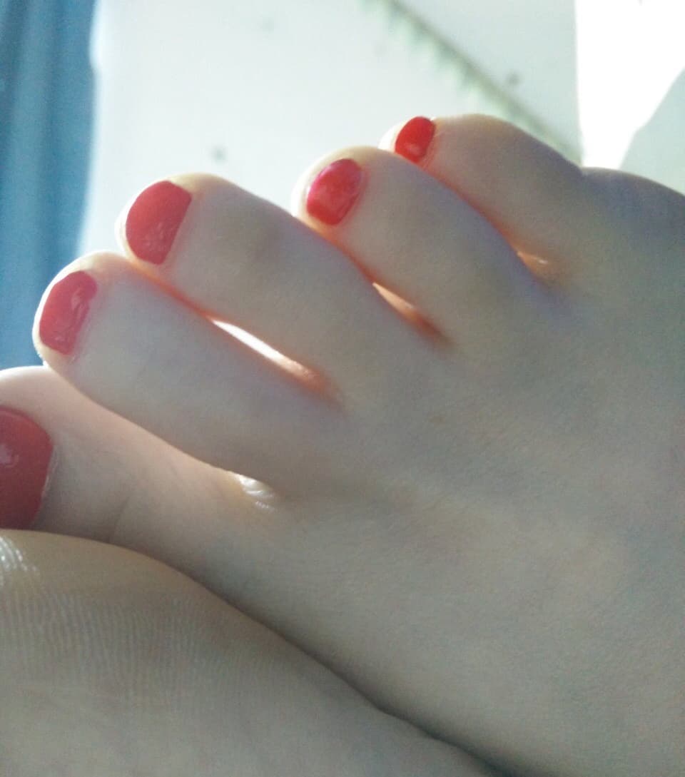 Glamorous shot of an ankle in sheer white stocking, toes pointed with glossy nail polish