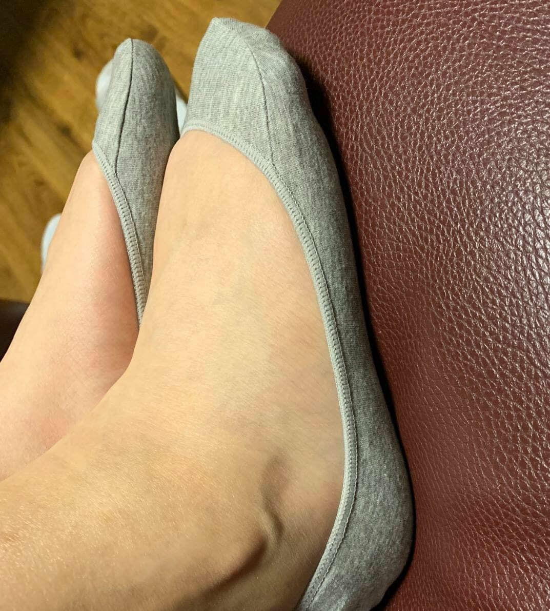 Worn cotton sock cradling a relaxed foot, fibers softened and gently stretched