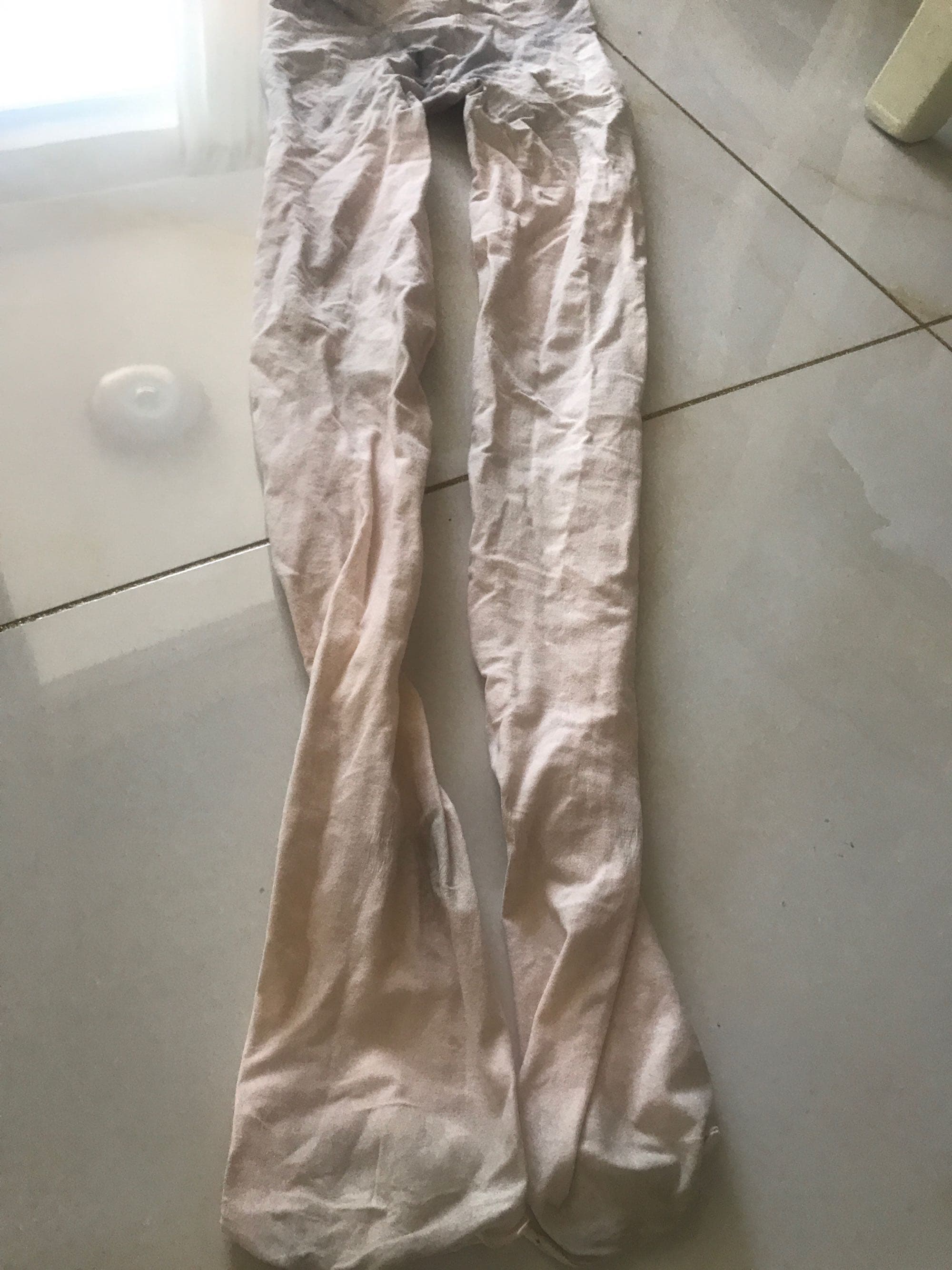 Dynamic shot of a dancer’s bare feet mid-pose, stockings shimmering and toes flexed in elegant motion