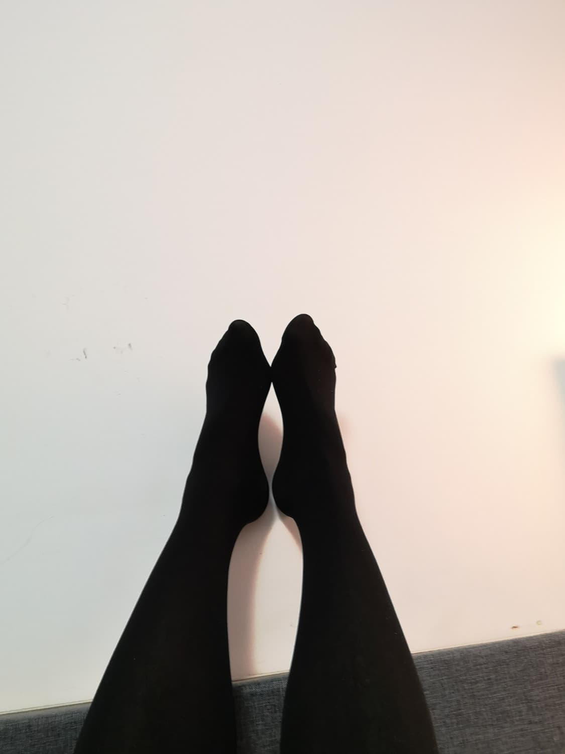 Casual close-up of slightly worn cotton socks and bare toes peeking out, cozy mood and warm tones