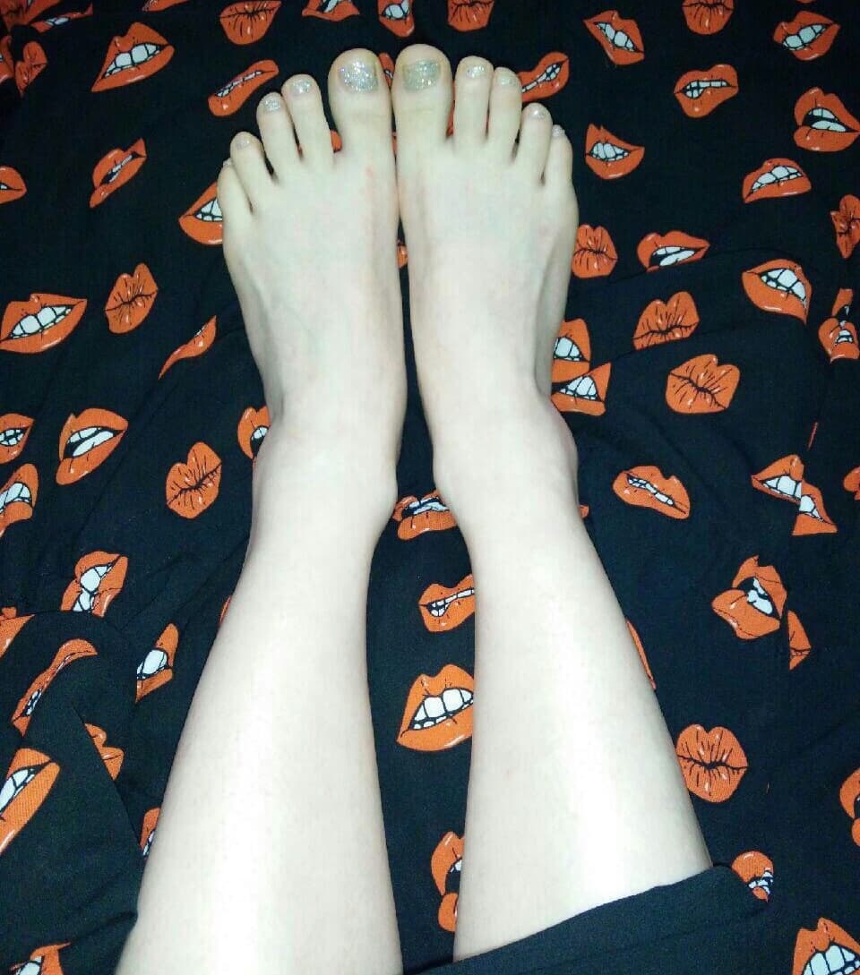 Sheer nylon stretched over toes, heel slightly lifted, light catching the glossy texture