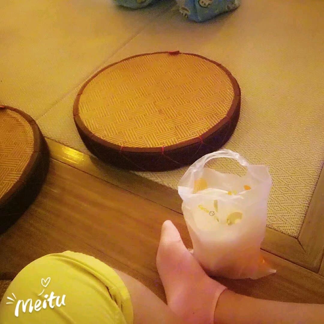 Bare Asian soles resting against soft fabric, toes slightly curled under sheer black stockings