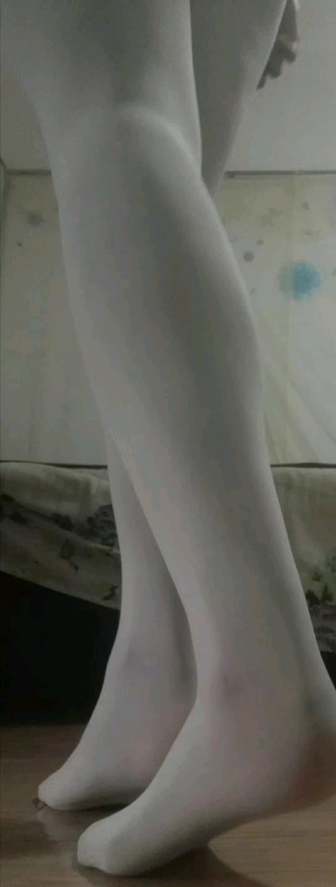 Close shot of dancer's feet in white dance socks, arches flexed and toes pointed with subtle fabric stretch