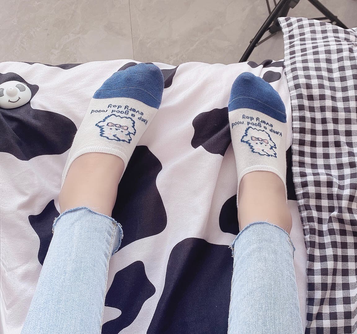 Close-up of bare feet with soft arches and painted toenails resting on plush fabric, subtle nylon sheen visible