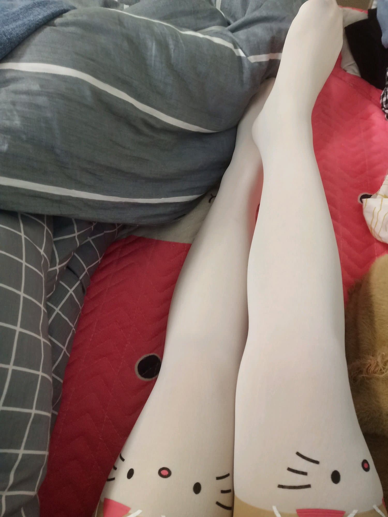 Relaxed scene of feet out of shoes, stockings rolled at ankles, toes splayed comfortably on a soft surface