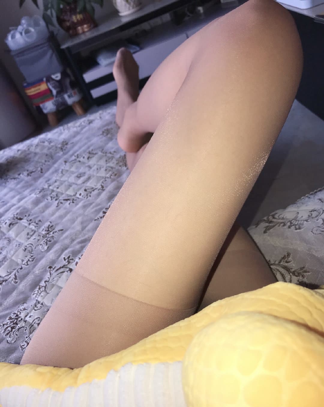 Home scene of legs in silky stockings, graceful ankles and smooth calves softly lit in cozy interior