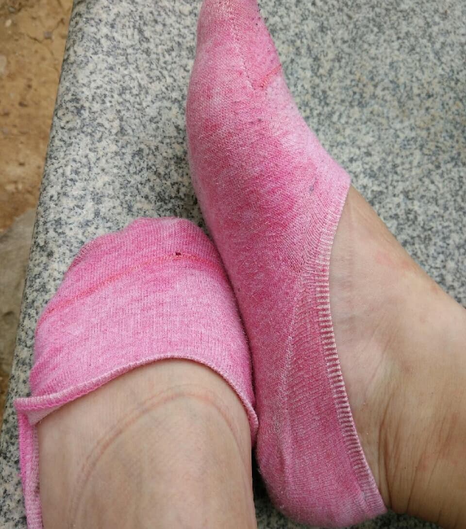 Sunlit bare feet with sheer nylon sheen, toes curled gently, soft arches highlighted by warm afternoon glow