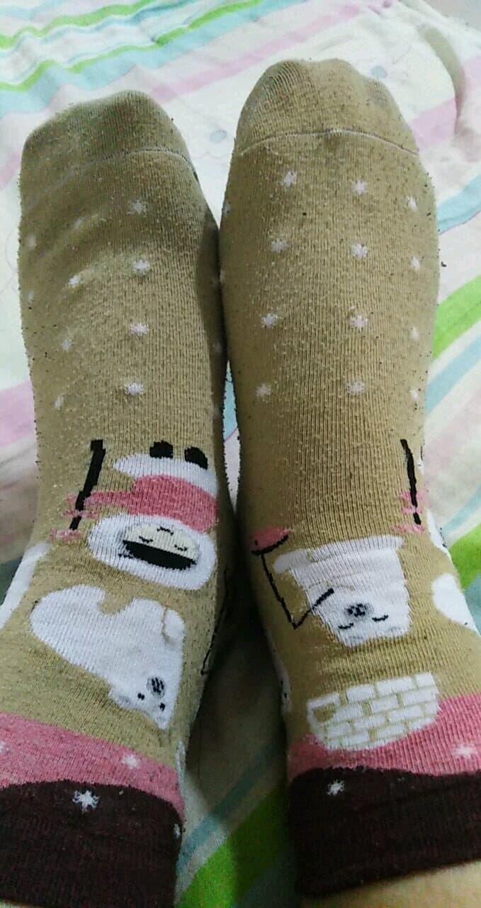 Evening sidewalk scene with a lone stocking draped over a bench, soft streetlight and shadowed pavement