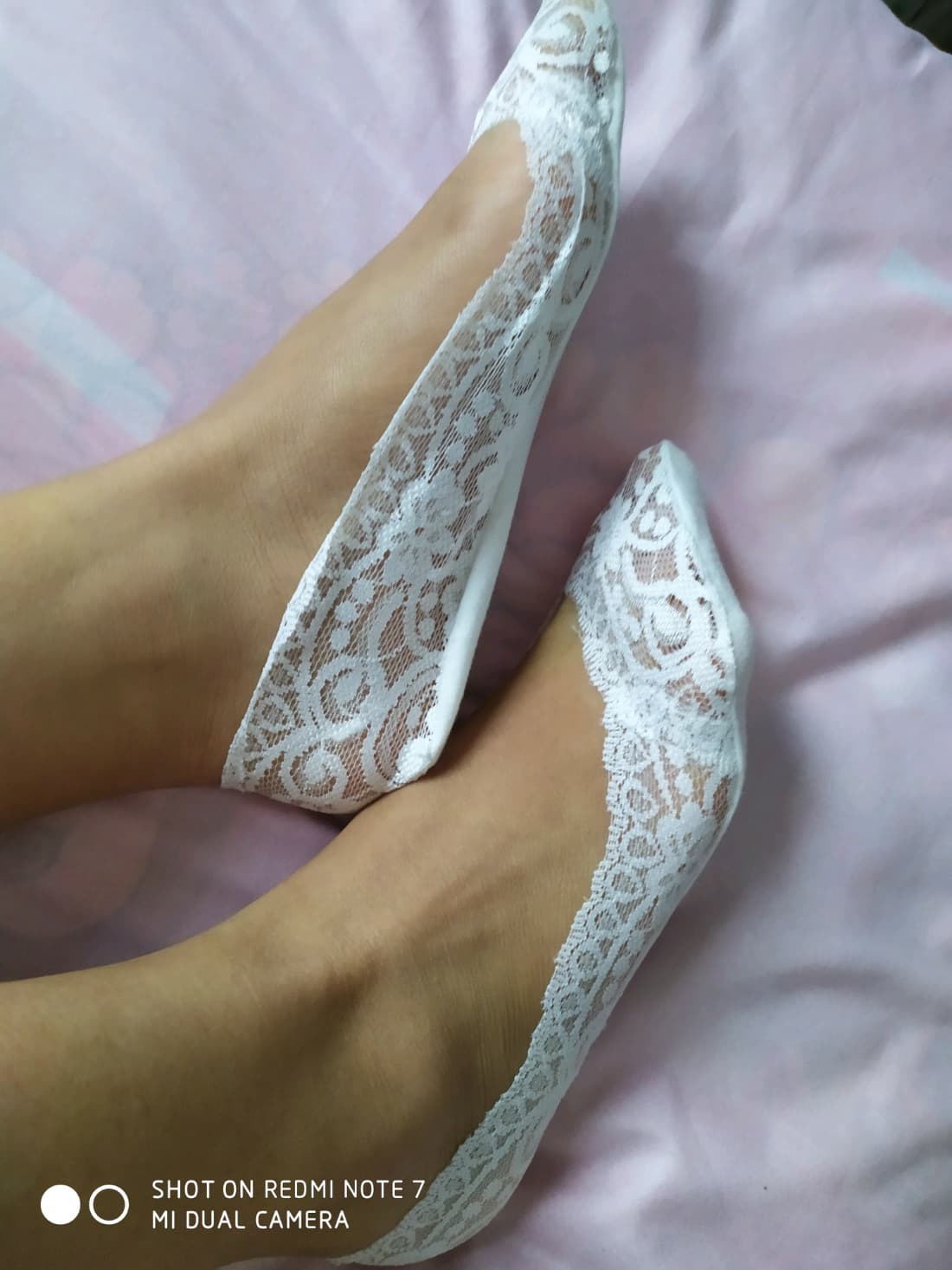 Feet in worn cotton socks curled on a sofa, warm ambient light and a relaxed, intimate mood