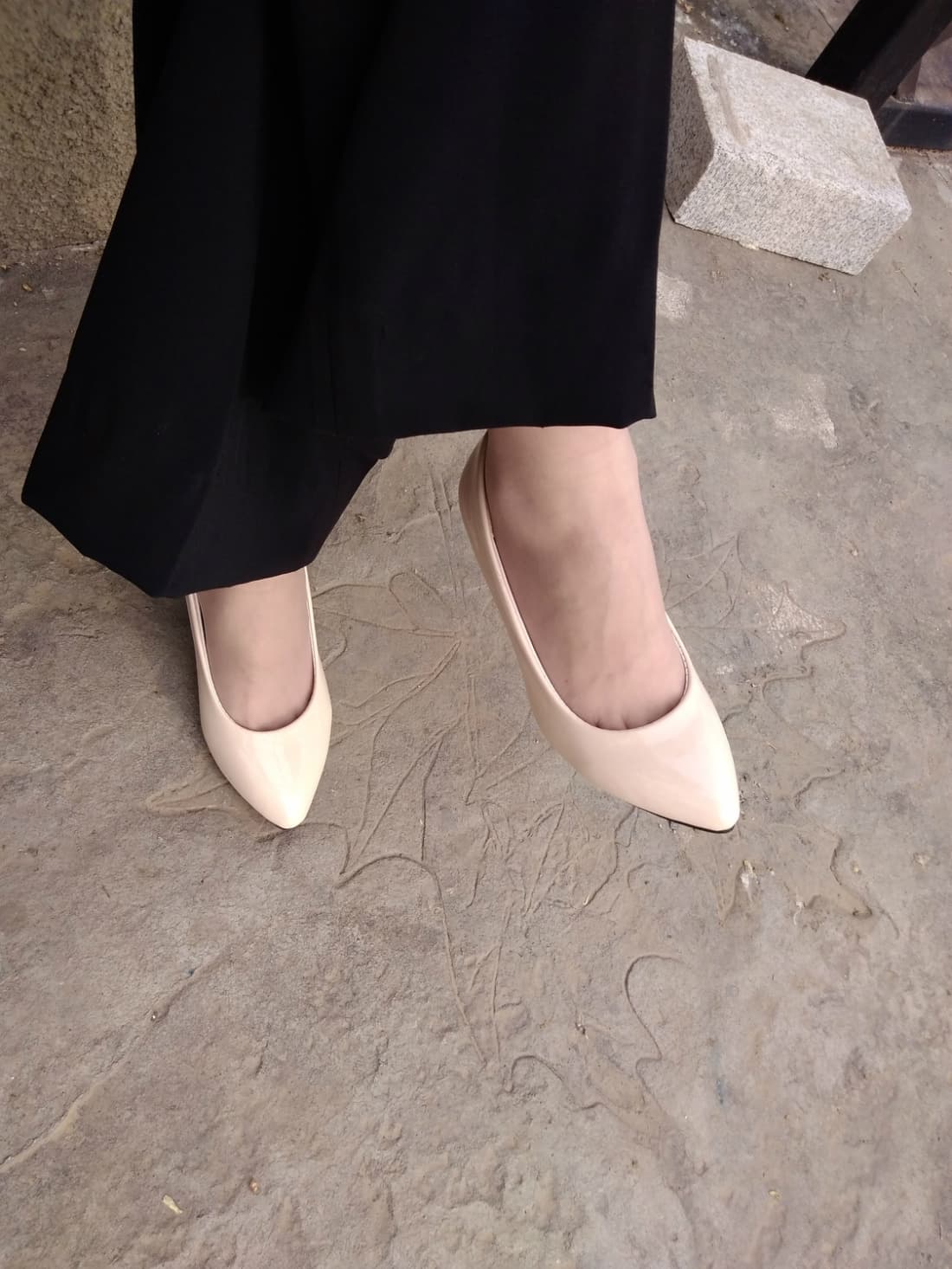 Side view of legs in short stockings paired with glossy high heels, emphasis on arch and calf contour