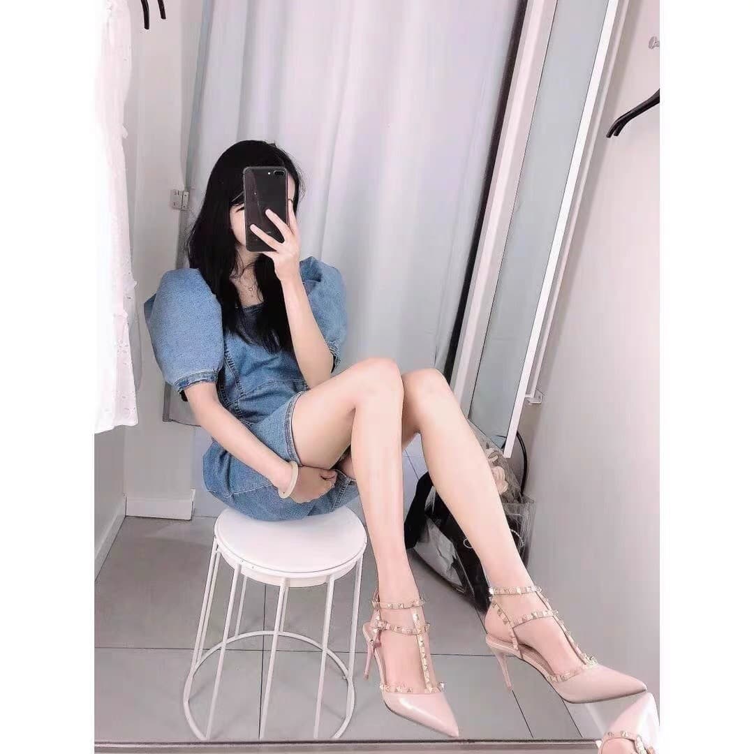 Detail of nylon-clad toes peeking from a pump, heel raised and glossy stockings catching the light.