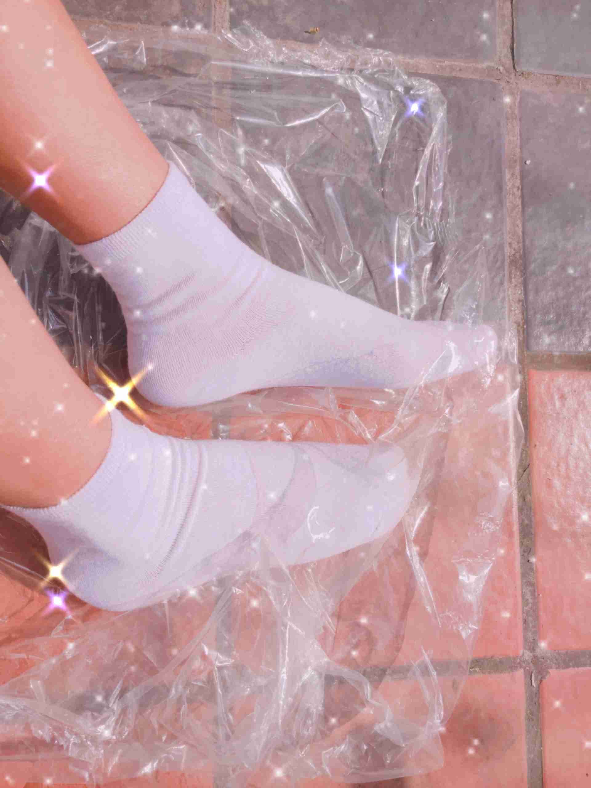 Foot relaxed in plain white cotton sock, cuff slightly rolled and heel softly exposed