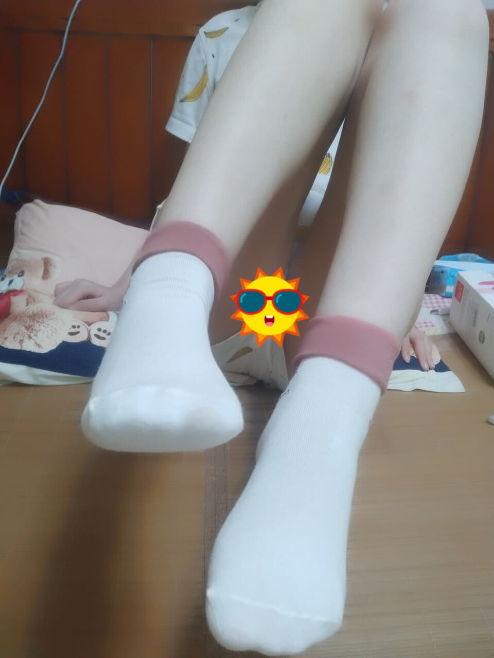 Close view of adult feet wearing playful meow-patterned socks, toes slightly exposed and cotton fabric creased