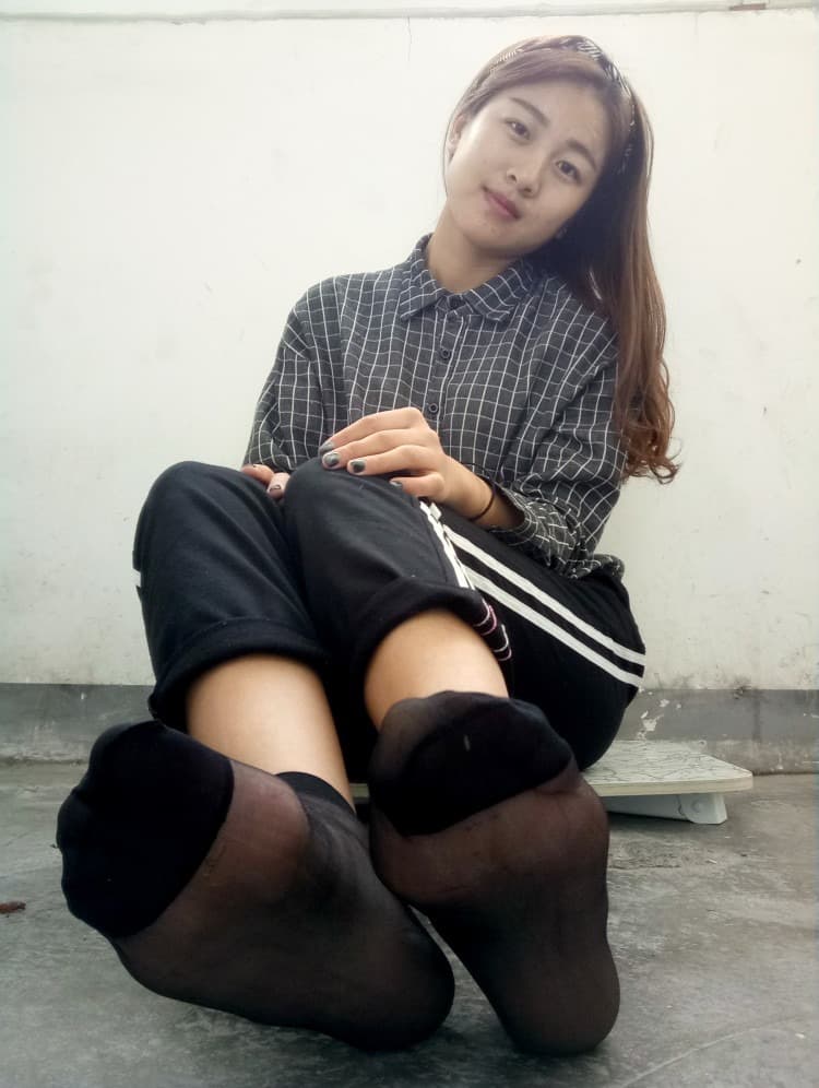 Elegant shot of black stockings hugging the calf, foot poised to reveal a smooth, inviting sole