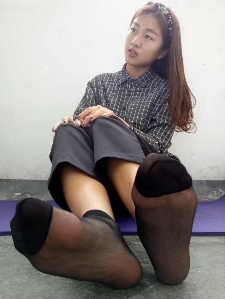 Artful close-up of a bare sole next to nylon-clad toes, contrasting textures and soft lighting