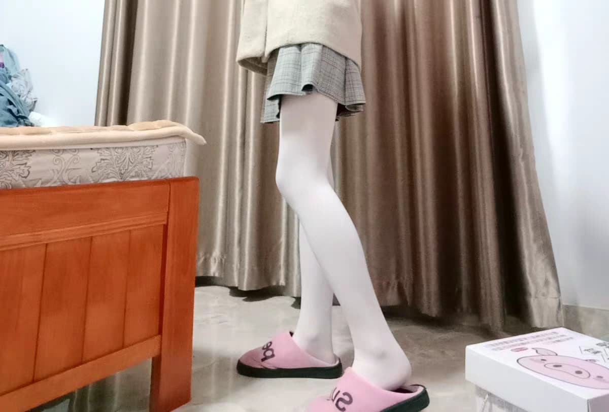 A playful pose with a foot extended, nylon stocking glinting as toes flex and catch the light in a suggestive way.