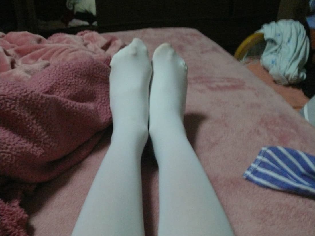 Shy newcomer’s feet in sheer stockings, toes slightly curled and ankles turned with tentative grace