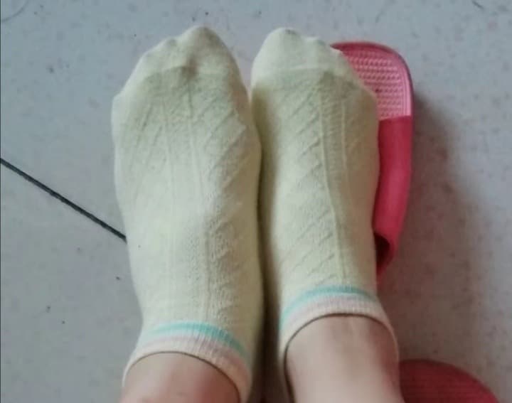 Comparison shot of bare feet, nylon-clad toes, and cotton-socked arches laid out for visual choice