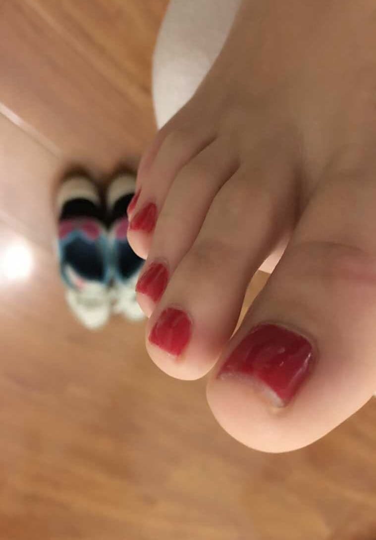 Bare feet emerging from cotton socks on a cozy bed, relaxed toes and soft lighting