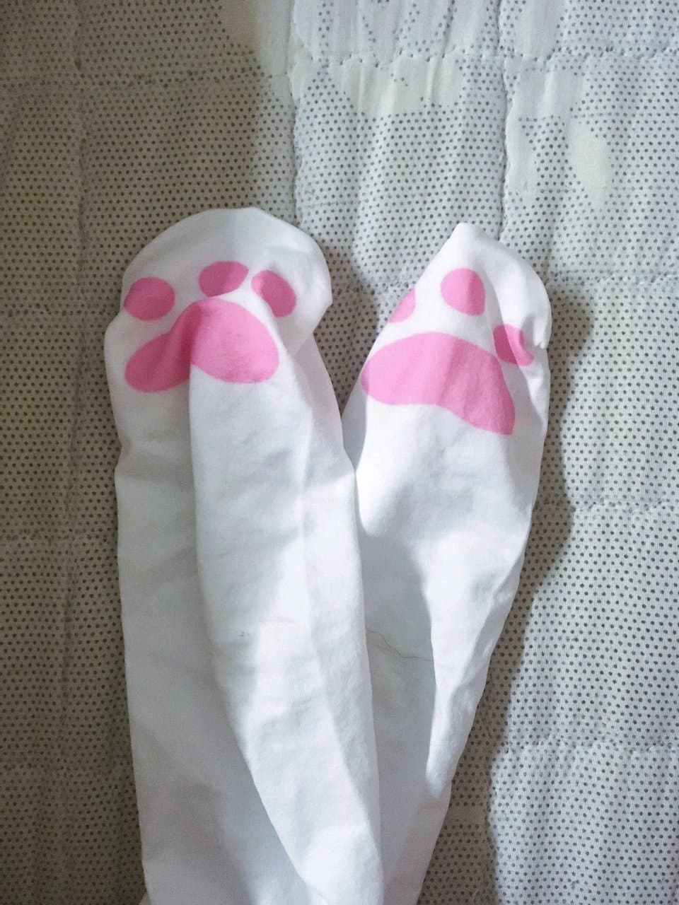 Small feet wrapped in patterned cotton socks, toes slightly parted, soft fabric folds visible