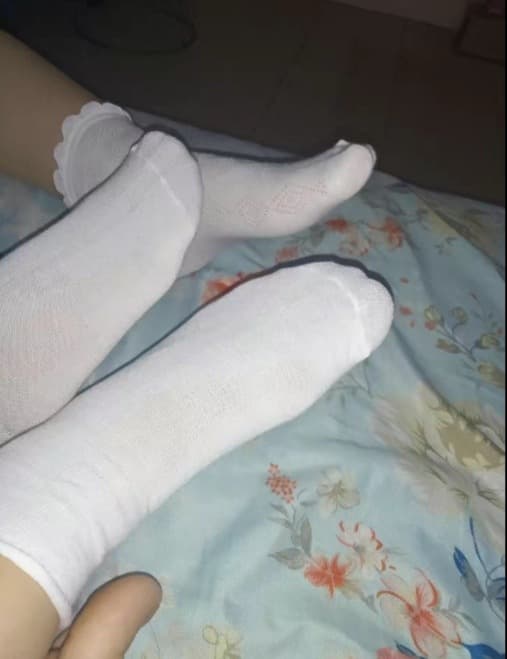 Soft-focus close-up of a foot in cotton sock, edges blurred to emphasize mood and gentle texture