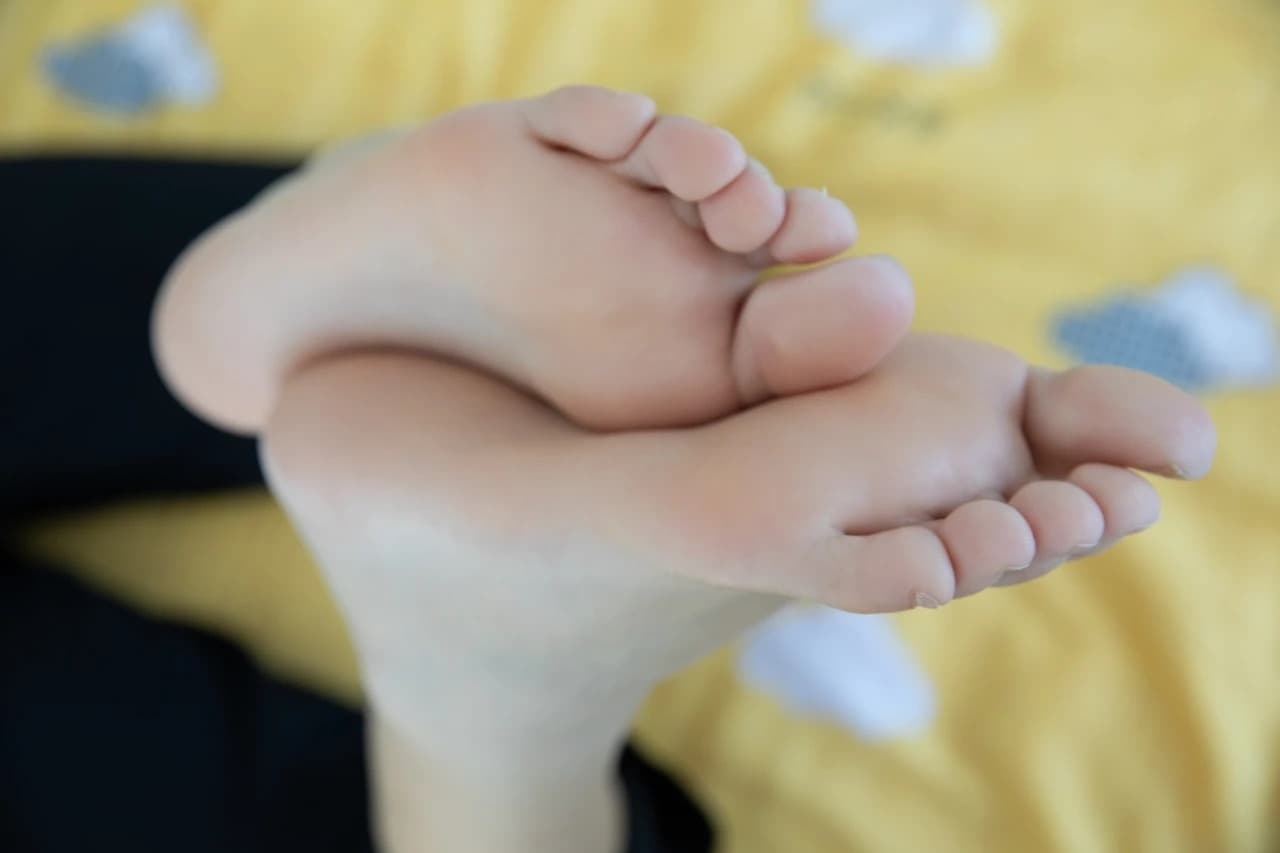 Side view of feet in sheer nylon and nearby cotton socks, suggesting gentle movement and quiet allure