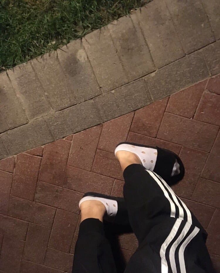 Close-up of holey cotton socks revealing bare toes and textured knit with frayed edges and soft wear