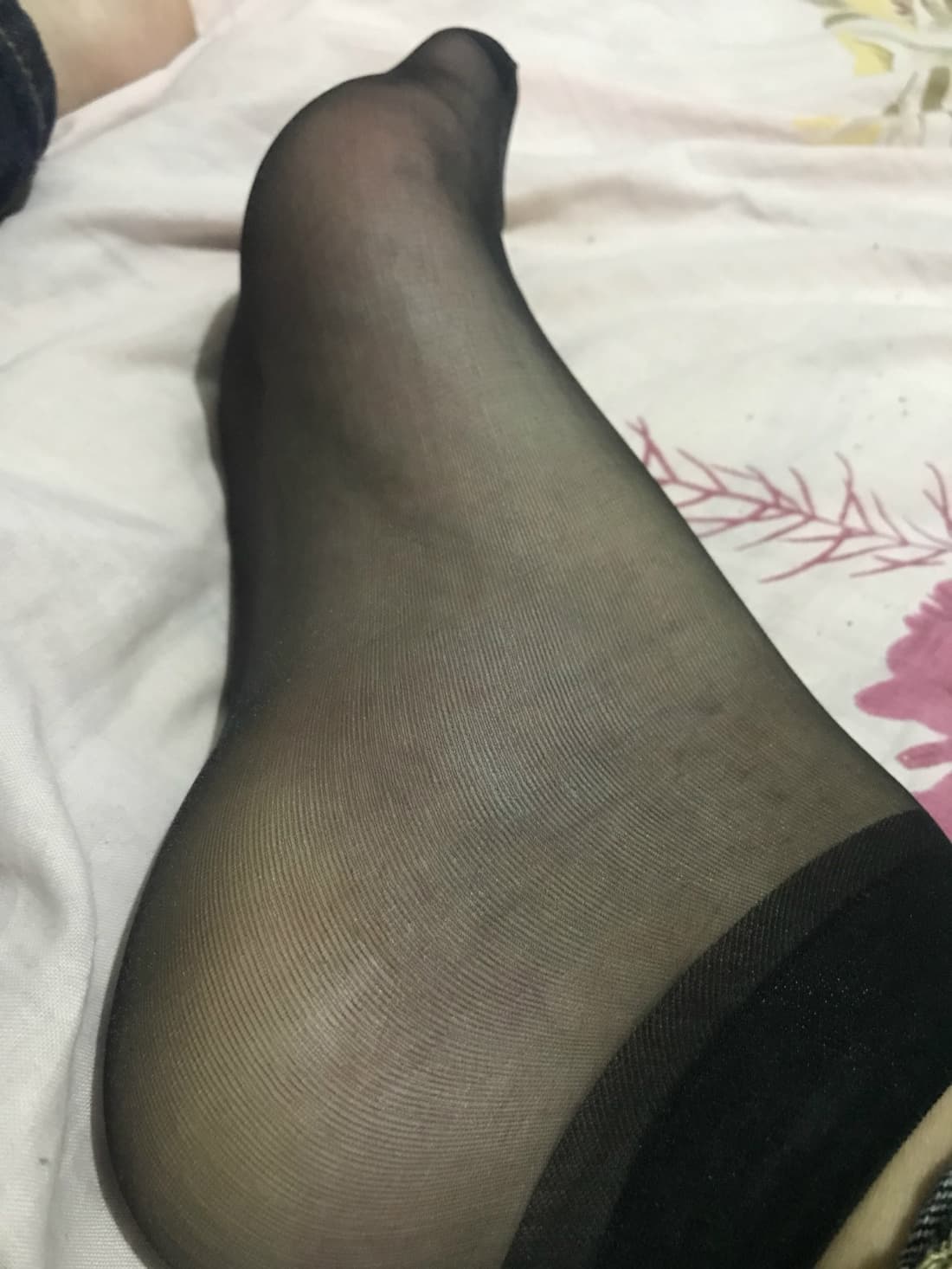 Silk-clad foot with glossy fabric hugging the toes, light reflecting off the smooth surface