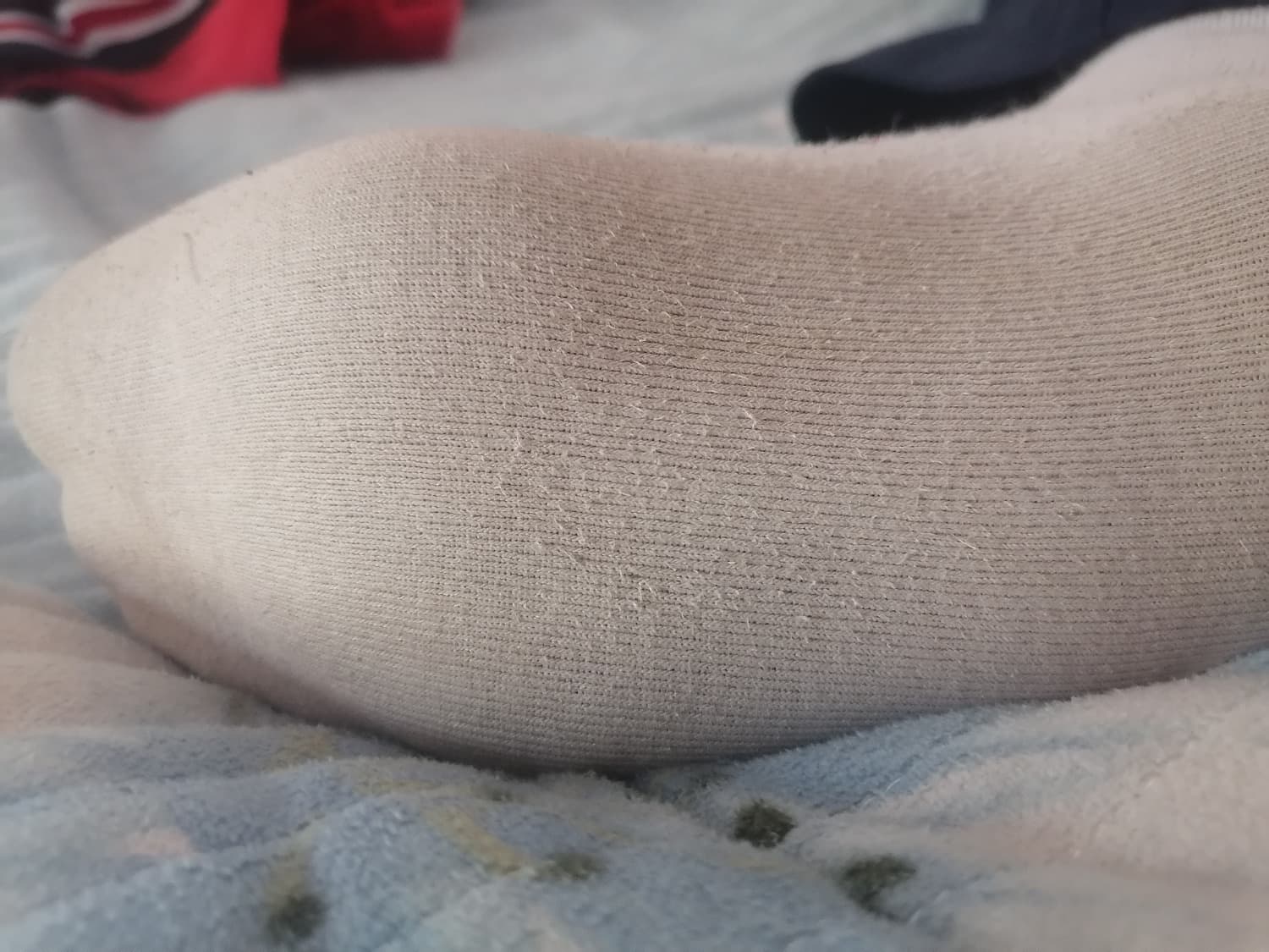 Foot resting on towel as used sock is slowly peeled down, revealing the sole marked by tiny traces of dirt