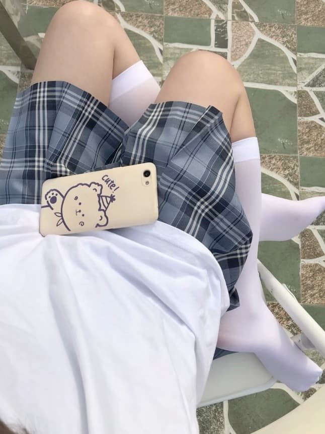 Close-up of a bare foot slipping into glossy silk stockings, toes curled and ankle flexed on soft bedding