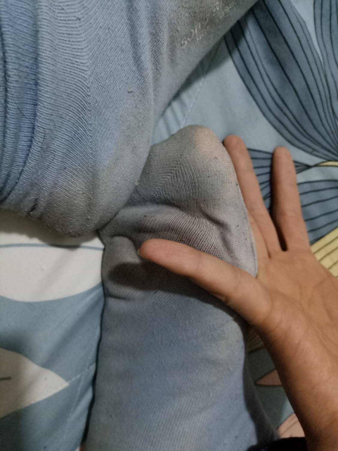 Well-worn cotton socks with gentle stretching, faint discoloration near toes, folded casually after long wear