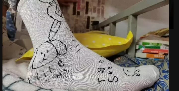 Close portrait of toes and arch, nylon sheen and soft skin in warm light