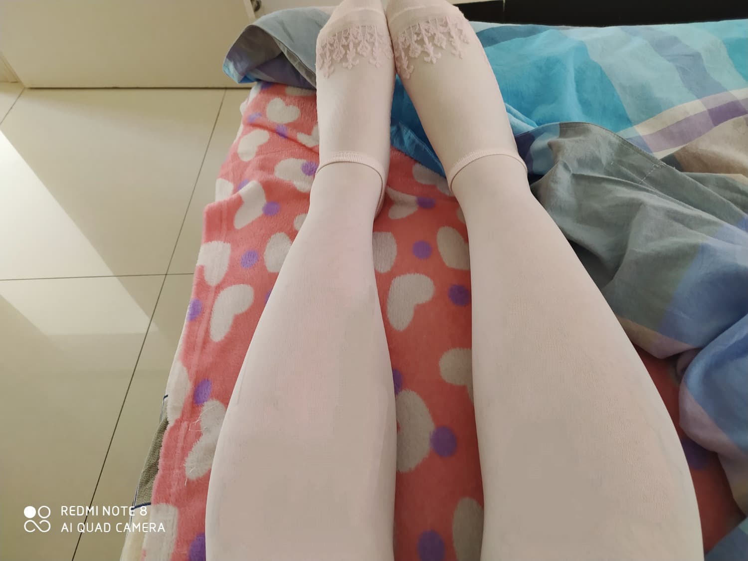 White silk draped over a leg, toes peeking from sheer fabric in soft, warm light