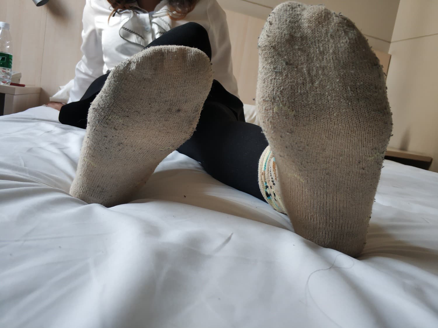 Cozy close-up of feet in slightly worn cotton socks, toes pressing and fabric showing soft texture