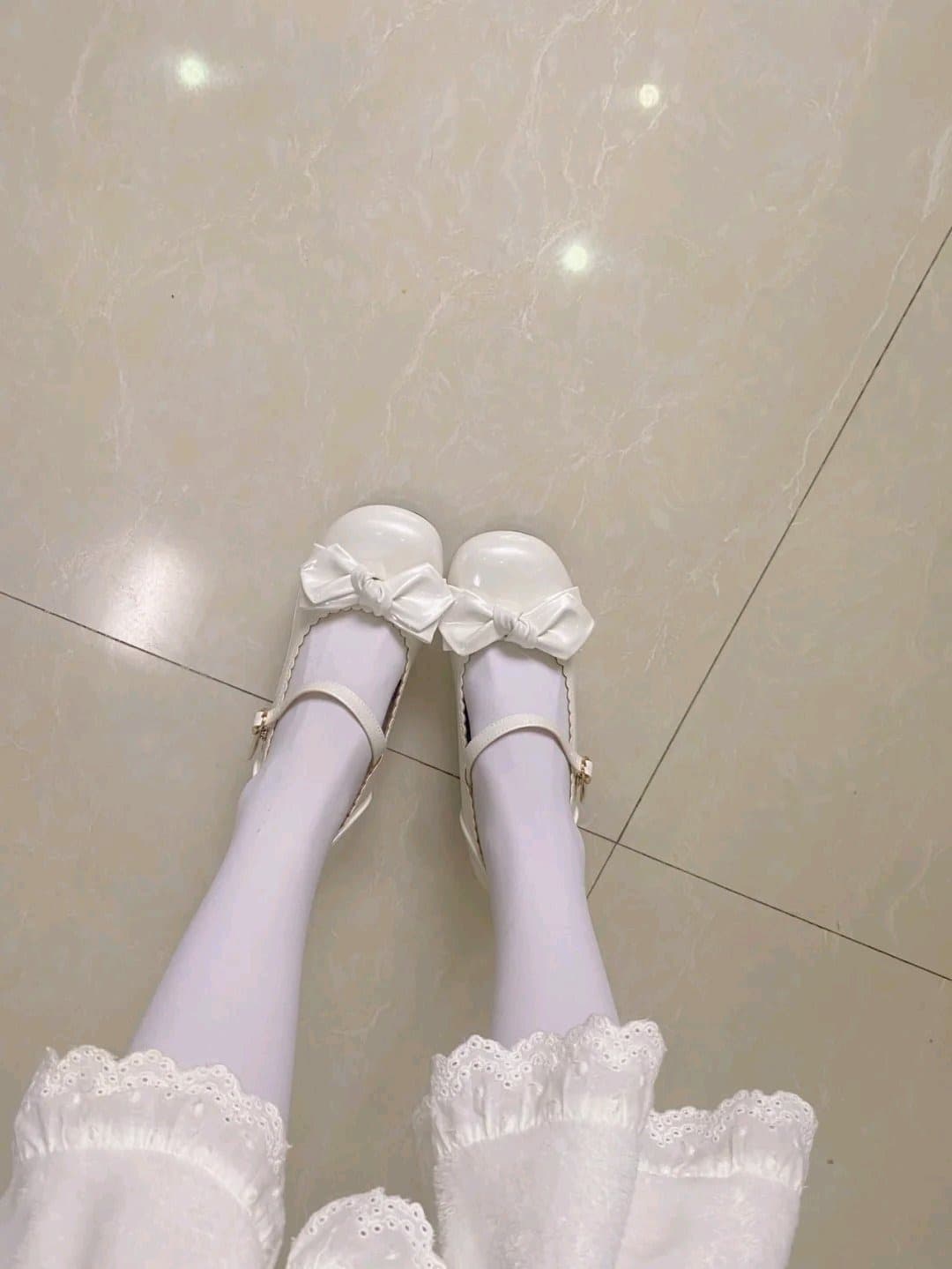 Close-up of stockinged ankle beside sandy foot, sunlight highlighting nylon sheen and subtle toe movement