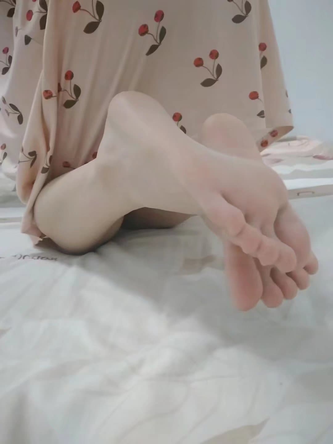 Bare soles resting on soft fabric, toes relaxed and natural, emphasizing sole texture and arch curvature