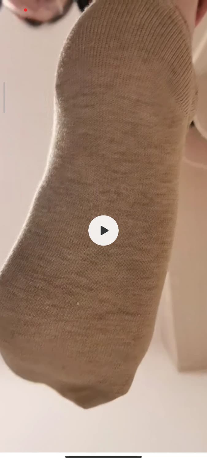 Bare soles pressing into plush fabric, toes splayed slightly, nylon sheen and fabric wrinkles creating intimate tactile contrast in close-up