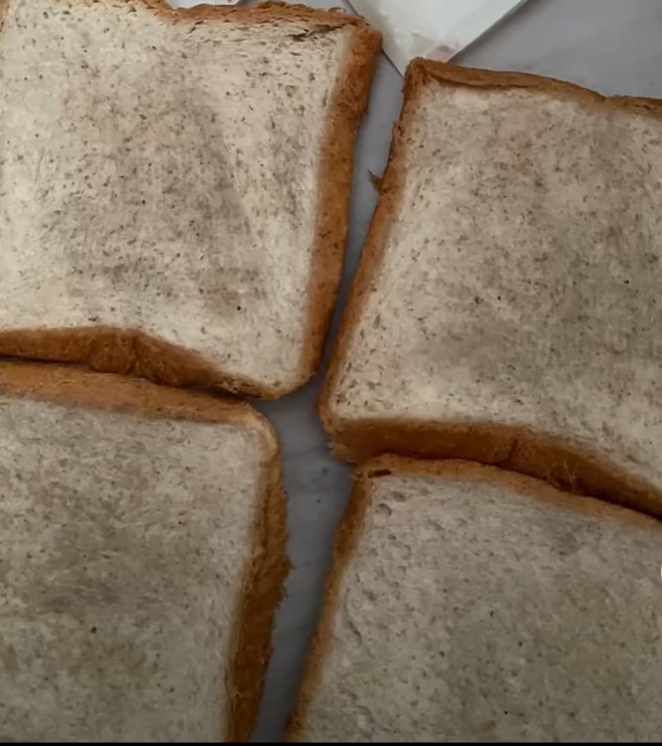 Side view of stocking-clad feet pressing into creamy dessert, delicate wrinkles in silk, soft skin contrasted with glossy food textures